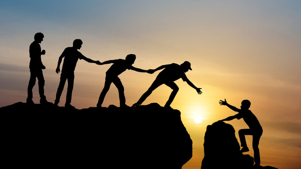 Group of people on peak mountain climbing helping team work , tr